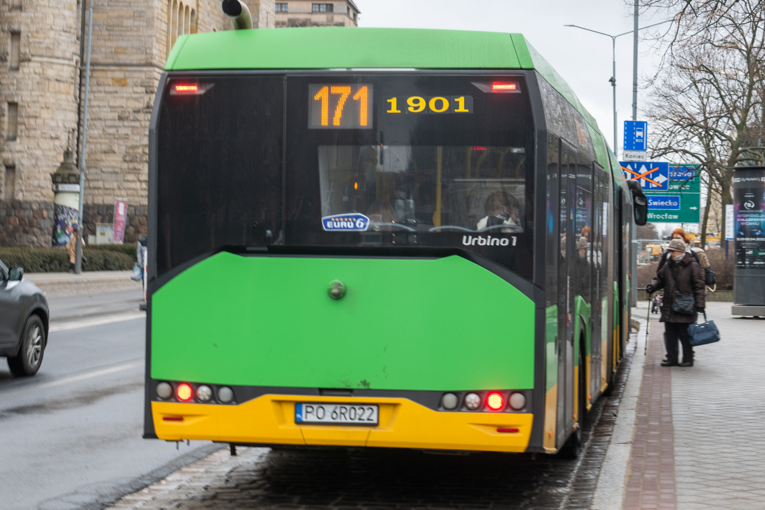 zielony autobus czekający na pasażerów w centrum miasta